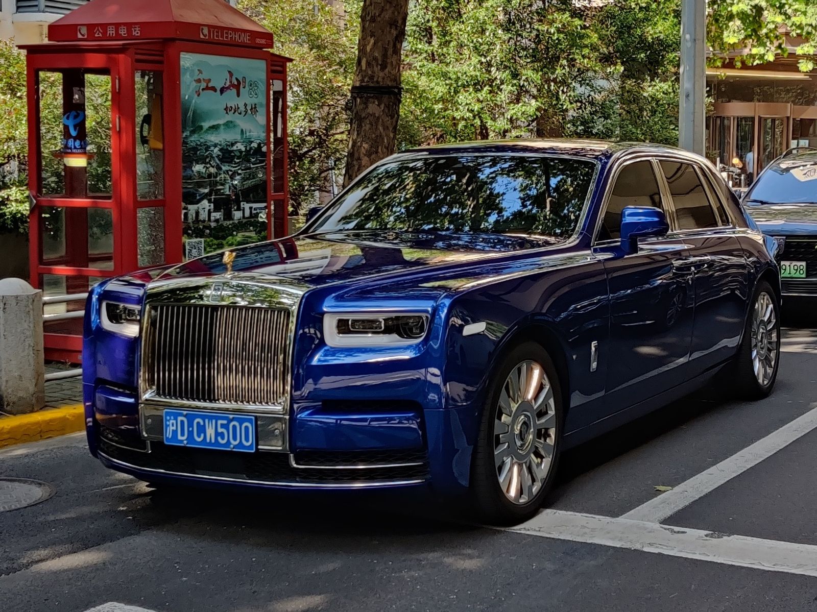 Blue Rolls-Royce Phantom VIII parked on a city street